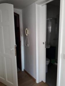 カスカイスにあるIn Cascaisのバスルーム(トイレ付)、壁掛け電話が備わります。