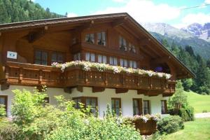 a building with a balcony with flowers on it at Haus Alpengruss in Sankt Leonhard im Pitztal