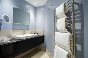 a bathroom with a sink, toilet, and mirror at Budock Vean Hotel in Helford Passage