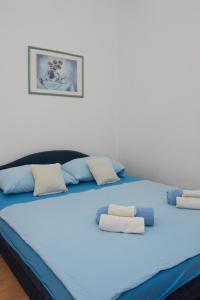 Una cama grande con sábanas azules y almohadas. en Rooms Vendi, en Daruvar