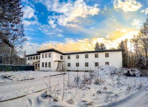 a white building with snow on the ground at DAS TANN rooms & wine in Thale