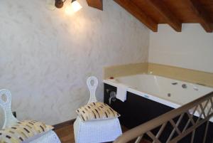 a bathroom with a bath tub and two chairs at Posada La Fabula in Santillana del Mar +108 photos
