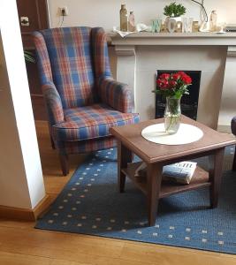 a living room with a chair and a table with a vase of flowers at eXo Hotel Franka Bamberg - by NeVo Hotels in Hallstadt