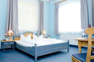 ein Schlafzimmer mit einem Bett in einem blauen Zimmer in der Unterkunft Hotel & Restaurant Haus am See in Löcknitz