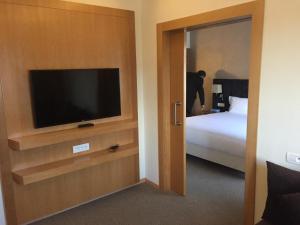 a hotel room with a television and a bed at Annakhil Hotel in Rabat