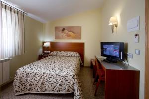 Habitación de hotel con cama y TV de pantalla plana. en Hotel Marivella, en Calatayud