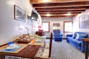 a living room with a table and a blue couch at Peggy Guggenheim Venice Apartment in Venice
