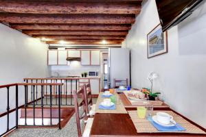 a dining room with a table and a kitchen at Peggy Guggenheim Venice Apartment in Venice