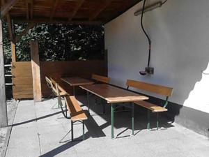 two benches and a table and chairs on a patio at Pferdehof und Wanderreitstation Dörsam in Mörlenbach