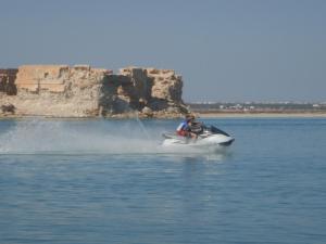 a man on a jet ski in the water at Maison les Palmiers 300m de la plage in Aghīr