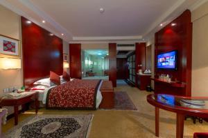 a bedroom with a bed and a television in a room at Dunhuang Hotel in Dunhuang