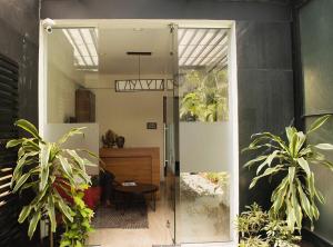 a glass door leading into a room with plants at Hotel Cozy Inn in Pune