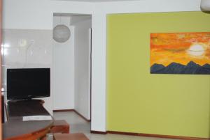 a room with a green wall with a painting on it at Residencial Raiar in Mindelo