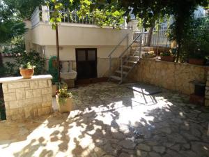 a house with a staircase and a stone patio at Apartments villa MaVeRo in Banjole