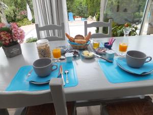 a table with two cups and a tray of breakfast food at Le Chalet Bleu in Vergt-de-Biron