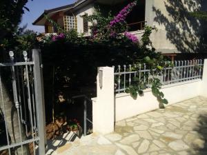 a fence in front of a house with flowers at Apartments villa MaVeRo in Banjole