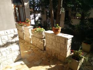 a retaining wall with potted plants on it at Apartments villa MaVeRo in Banjole
