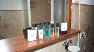 una mensola con diverse bottiglie di prodotti per capelli di fronte a uno specchio di B&B La Casa Rosa a Balze Altre 37 foto