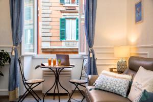 ローマにあるBoutique Domus Trastevere Bertaniのリビングルーム(ソファ、テーブル付)、窓が備わります。