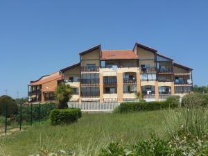 an apartment building with balconies and a yard at Capbreton Notre-Dame in Capbreton