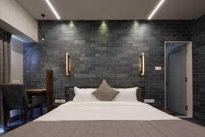 艾哈迈达巴德Hotel Carrefour的一间带大床和砖墙的卧室