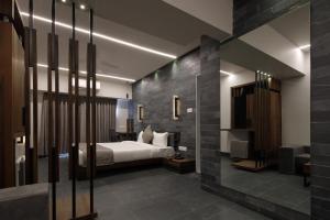 アーメダバードにあるHotel Carrefourのベッドとテレビが備わるホテルルームです。