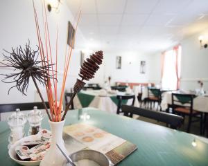 a green table with a vase with sticks in it at Pearl Hotel in Blackpool