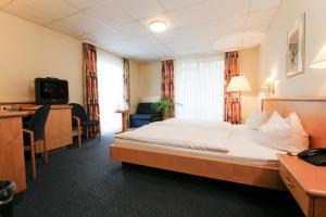 a hotel room with a bed and a desk at Kurparkhotel Das Kleinod in Bad Kissingen