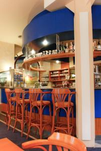 un bar avec des chaises en bois dans un restaurant dans l'établissement Kurparkhotel Das Kleinod, à Bad Kissingen