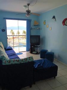 a living room with a couch and a flat screen tv at Apto Litoral Norte Caraguatatuba in Caraguatatuba