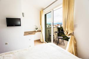 a bedroom with a bed and a view of a balcony at Villa Suzy Lux in Sutivan