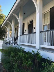a white house with white columns and a porch at Riverboat Bed & Breakfast in Natchez