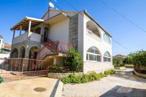 ein weißes Haus mit einer roten Treppe davor in der Unterkunft Apartments Gea in Trogir