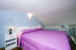 a bedroom with a pink bed with a purple blanket at Casa Amore S Lucia in Amalfi