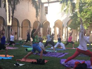 a group of people doing yoga in the grass at Il Chiostro Hostel and Hotel in Alessandria