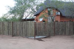 a wooden fence in front of a house at Mushi Maningi in Hoedspruit