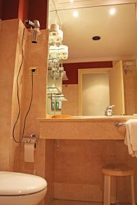 ein Badezimmer mit einem Waschbecken, einem WC und einem Spiegel in der Unterkunft Al Sur de Chipiona in Chipiona