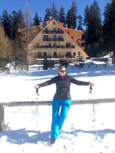 a woman standing in the snow with ski poles at Ski apartmány Spiežovec Donovaly in Donovaly