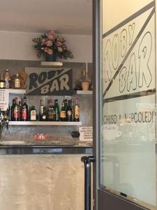 una habitación con un bar con botellas de alcohol en Roby Bar Affittacamere, en Romentino