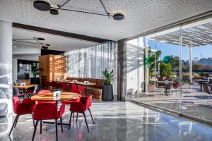 a large dining room with a large window at Barceló Sevilla Renacimiento in Seville
