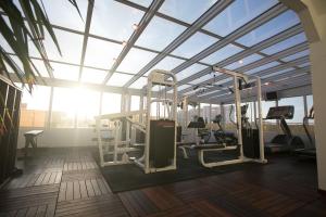 a gym with tread machines in a room with a large window at Verdanza Hotel in San Juan