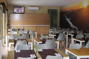 a restaurant with tables and chairs and a screen at Beleza Serra Guide Hotel in Geres