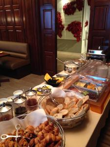 a buffet with many different types of bread and pastries at Le Windsor, Jungle Art Hotel in Nice