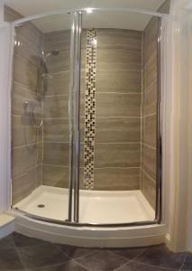 a shower with a glass door in a bathroom at Kingsmede Bed & Breakfast in Ventnor