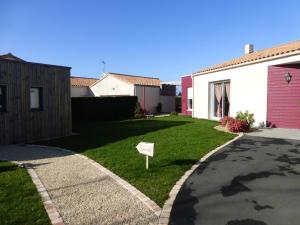 a house with a yard with a sign in the grass at La cabane du Bonheur in Les Herbiers +11 photos