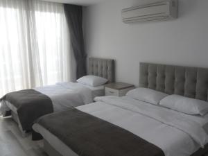 um quarto com 2 camas e uma janela em Guckar Sehrinn Oteli em Serik