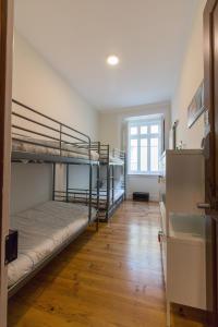 Change The World Hostels - Cascais - Estoril في مونتي استوريل: غرفة بسريرين بطابقين وأرضية خشبية