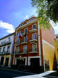 un bâtiment orange avec balcon dans une rue de la ville dans l'établissement Hotel Bruman, à Caserte