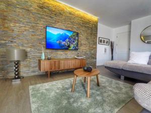 a living room with a tv on a brick wall at House Colegio de Gaia in Vila Nova de Gaia