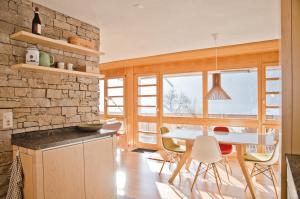 グリンデルワルトにあるApartment Matterhorn - GRIWA RENT AGのレンガの壁、テーブルと椅子付きのキッチンが備わります。